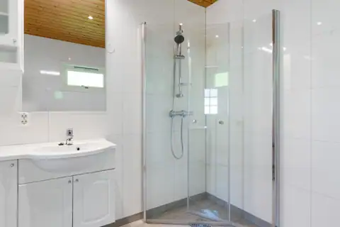 Det funksjonelle dusjhjørnet har svingbare glassdører, perfekt for en fleksibel romløsning.