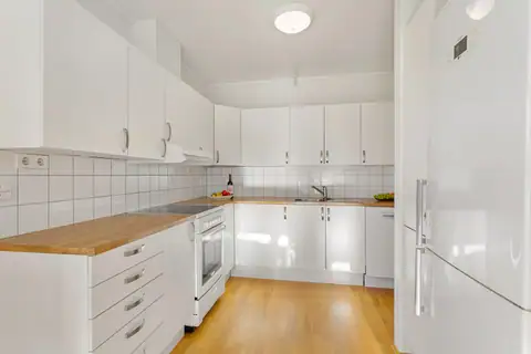 A bright, well-arranged kitchen with tiles above the worktop.